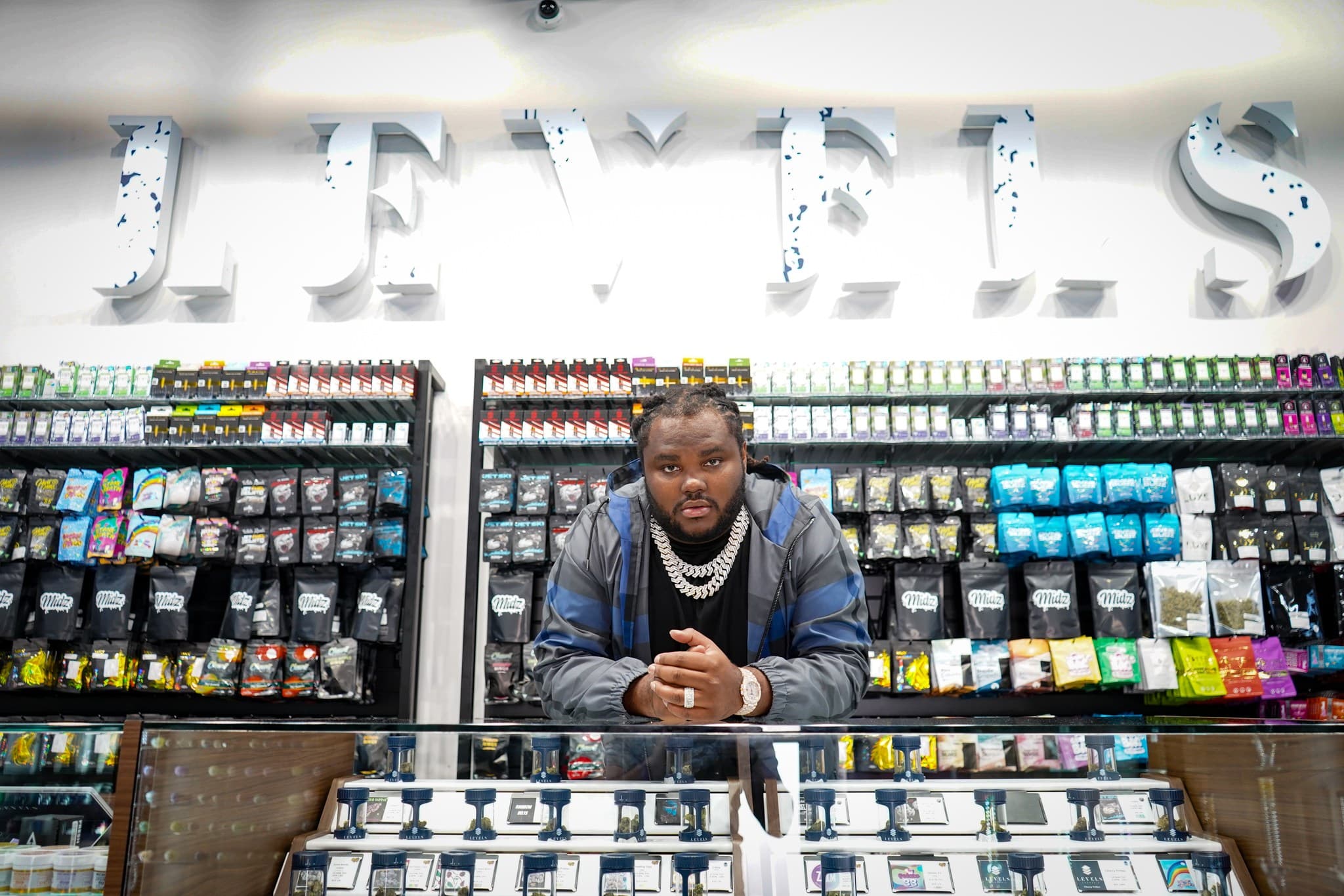 Inside Levels Cannabis – Premium Michigan Dispensary A team member standing behind the counter at Levels Cannabis, surrounded by cannabis products on display in a modern Michigan dispensary.